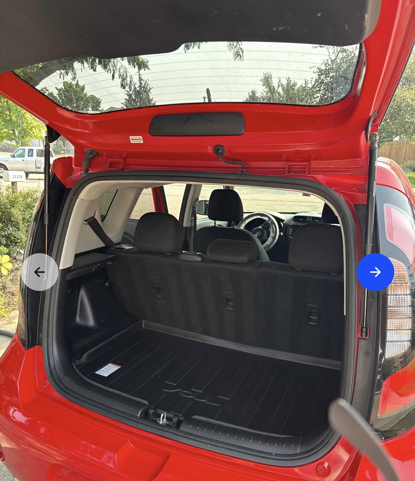 Clean open trunk of a red Kia Soul with a rubber liner after detailing