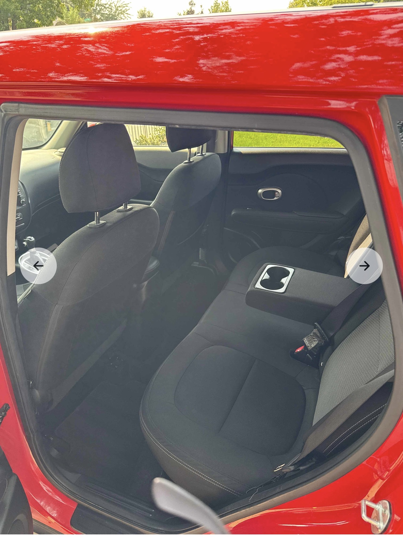 Clean black fabric rear seats of a red Kia Soul after detailing